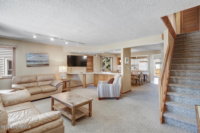 21 Brown Ave Unit 1, Lavallette, NJ 08735 - living room featuring track lighting, a textured ceiling, light carpet, and stairs