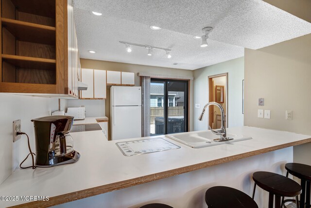 21 Brown Ave Unit 1, Lavallette, NJ 08735 - kitchen with a breakfast bar area, a peninsula, a sink, and freestanding refrigerator