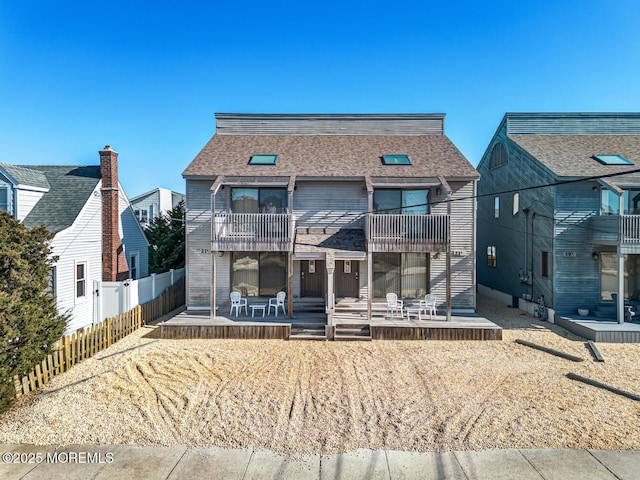 21 Brown Ave Unit 1, Lavallette, NJ 08735 - rear view of house with a fenced backyard, a shingled roof, a patio, and a balcony