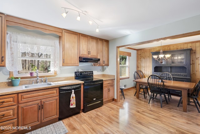 kitchen featuring black appliances, light wood-style flooring, light countertops, and a sink