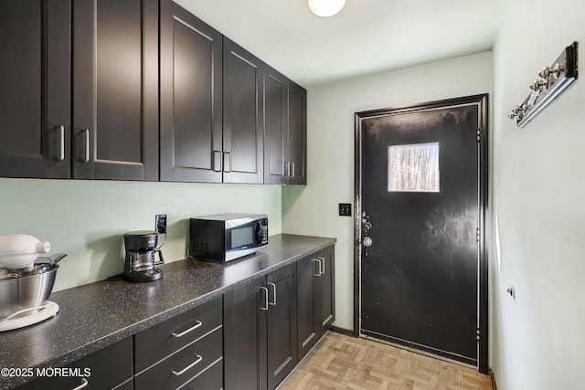 kitchen with dark stone counters and stainless steel microwave