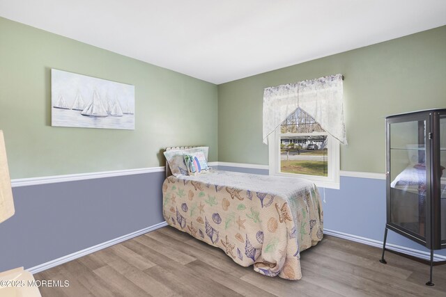 bedroom with baseboards and wood finished floors