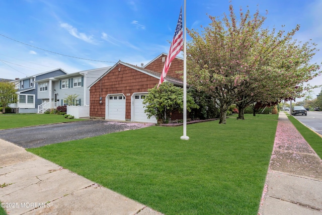 view of front of property featuring aphalt driveway, a front lawn, and an attached garage