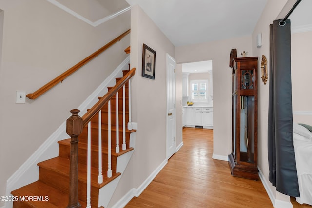stairs featuring wood finished floors and baseboards