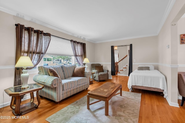 bedroom featuring wood finished floors, crown molding, and baseboards