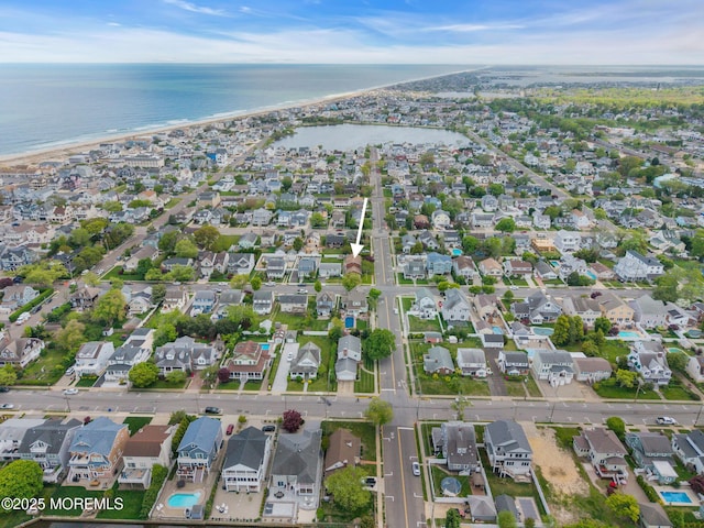 aerial view of property and surrounding area featuring a nearby body of water and nearby suburban area