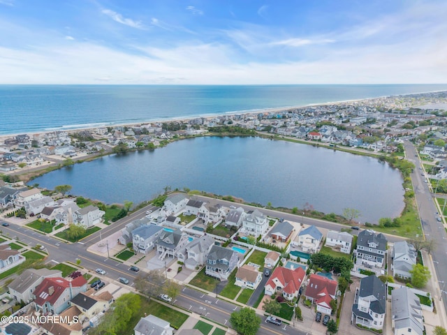 aerial view of property and surrounding area featuring a large body of water and nearby suburban area
