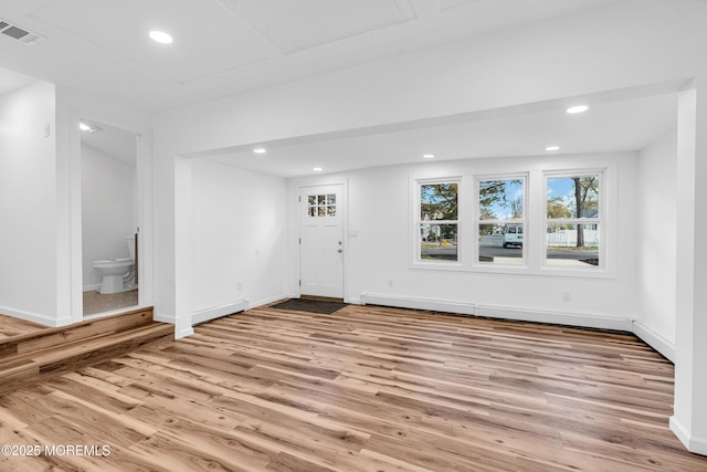 interior space featuring a baseboard heating unit, wood finished floors, visible vents, and recessed lighting