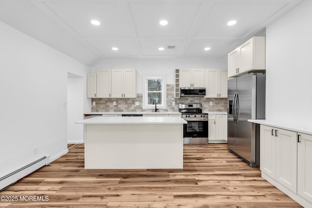 kitchen with a baseboard radiator, light wood-style floors, stainless steel appliances, and recessed lighting