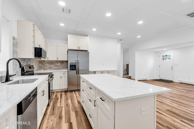 kitchen featuring recessed lighting, stainless steel appliances, coffered ceiling, a sink, and light wood-style flooring