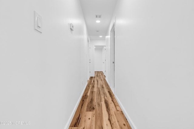corridor with baseboards, light wood-style floors, visible vents, and recessed lighting