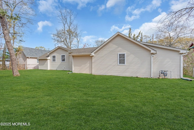 back of property with a yard and fence