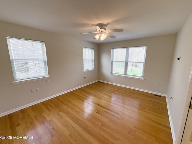 unfurnished room with light wood-type flooring, visible vents, baseboards, and ceiling fan