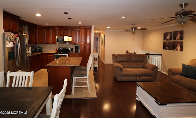 living area with recessed lighting, a ceiling fan, ornamental molding, and wood finished floors