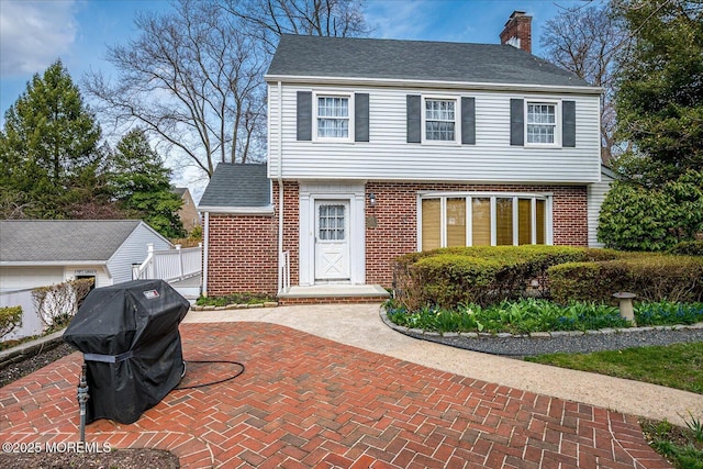 42 Pershing Ave, Sayreville Boro, NJ 08872 - colonial house with brick siding, a chimney, and a shingled roof