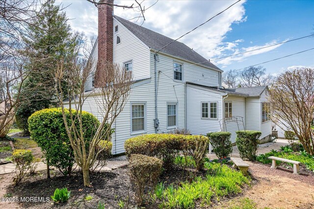 42 Pershing Ave, Sayreville Boro, NJ 08872 - view of side of home with a chimney and roof with shingles