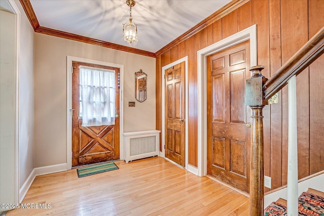 42 Pershing Ave, Sayreville Boro, NJ 08872 - foyer featuring crown molding, radiator heating unit, light wood-type flooring, wooden walls, and a chandelier