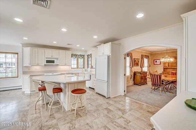 42 Pershing Ave, Sayreville Boro, NJ 08872 - kitchen featuring white appliances, ornamental molding, light countertops, arched walkways, and white cabinetry