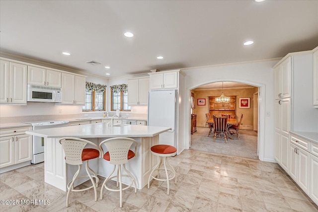 42 Pershing Ave, Sayreville Boro, NJ 08872 - kitchen featuring white appliances, arched walkways, light countertops, a center island, and recessed lighting