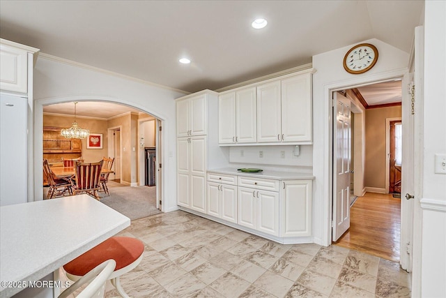 42 Pershing Ave, Sayreville Boro, NJ 08872 - kitchen featuring arched walkways, crown molding, light countertops, white cabinetry, and a chandelier