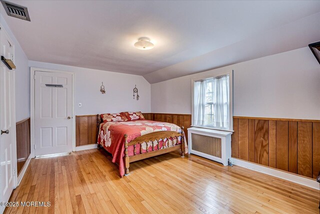 42 Pershing Ave, Sayreville Boro, NJ 08872 - bedroom featuring radiator, wainscoting, light wood-style flooring, wood walls, and vaulted ceiling