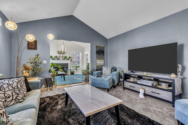 living area with carpet floors, high vaulted ceiling, and a fireplace