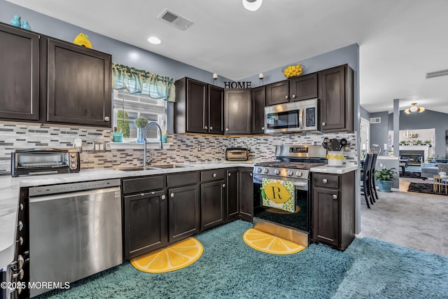 kitchen with visible vents, dark brown cabinetry, stainless steel appliances, and a sink
