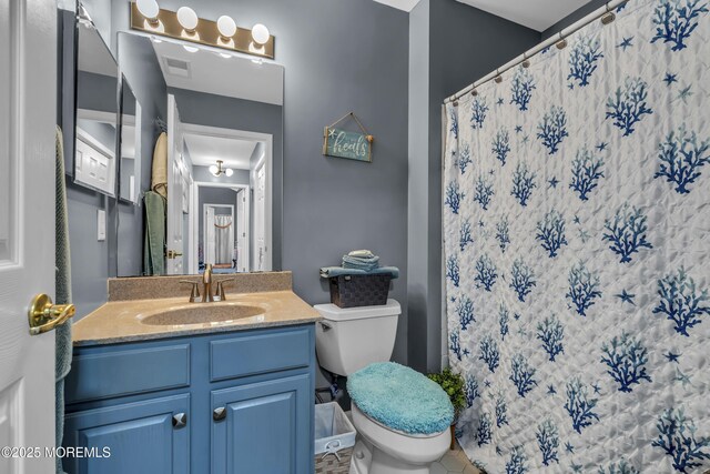 full bath featuring a shower with shower curtain, visible vents, toilet, and vanity
