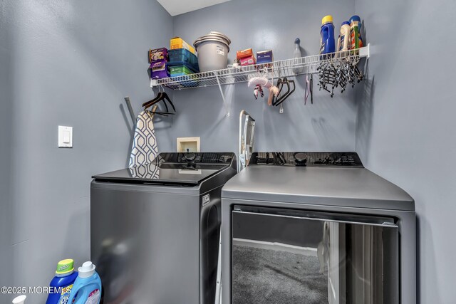clothes washing area featuring washing machine and clothes dryer and laundry area