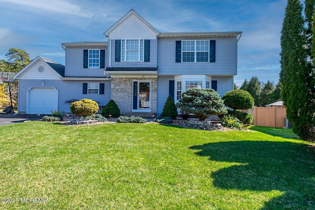 view of front of home with an attached garage, driveway, a front yard, and fence