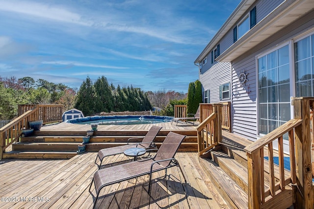 wooden terrace featuring an outbuilding and a covered pool