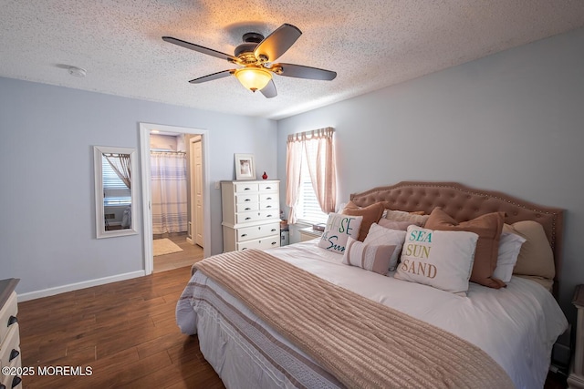 bedroom with baseboards, ensuite bath, a textured ceiling, a ceiling fan, and dark wood-type flooring