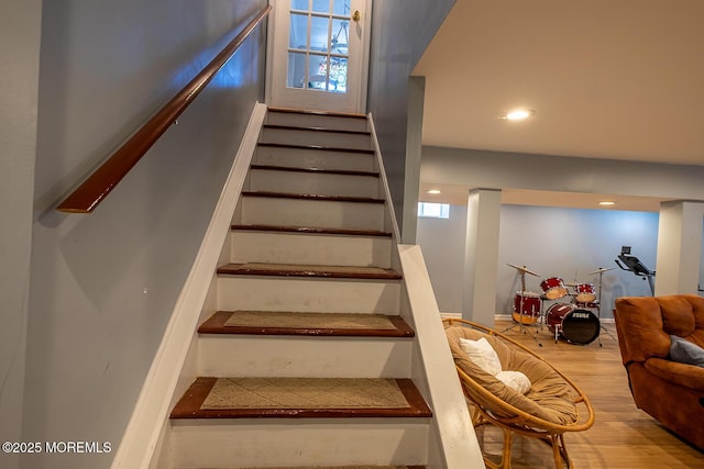 stairway with wood finished floors, recessed lighting, and a healthy amount of sunlight