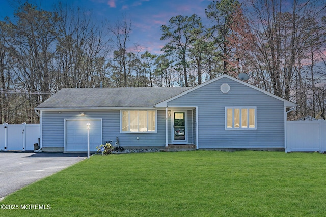 ranch-style house featuring driveway, a garage, fence, and a gate