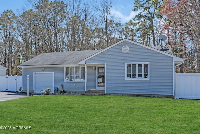 ranch-style home with a garage, fence, driveway, and a front lawn