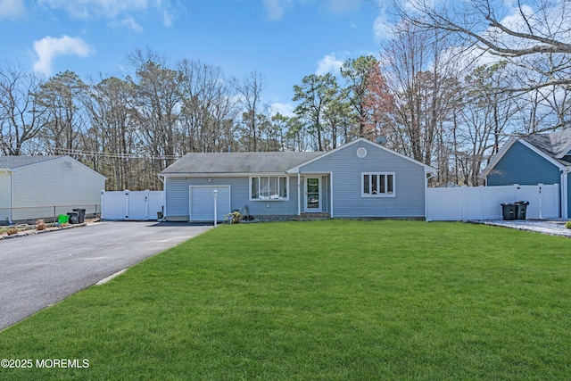 ranch-style home with driveway, fence, an attached garage, and a front lawn
