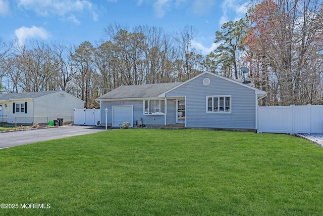 single story home with an attached garage, fence, a front lawn, and aphalt driveway