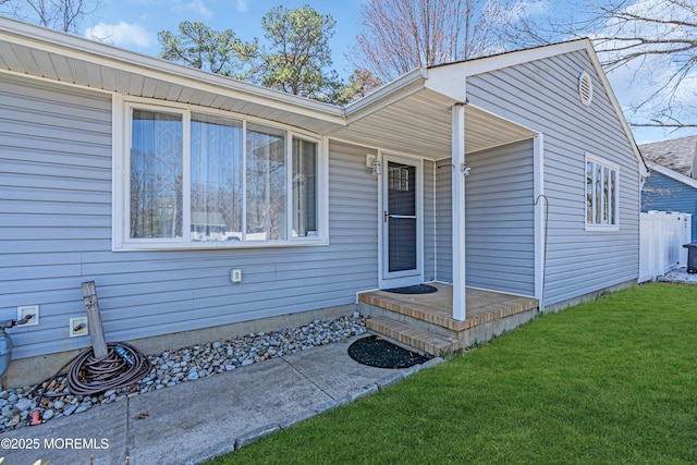 entrance to property with fence and a lawn