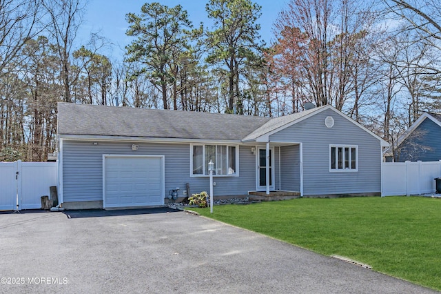 single story home with aphalt driveway, roof with shingles, a front yard, fence, and a garage