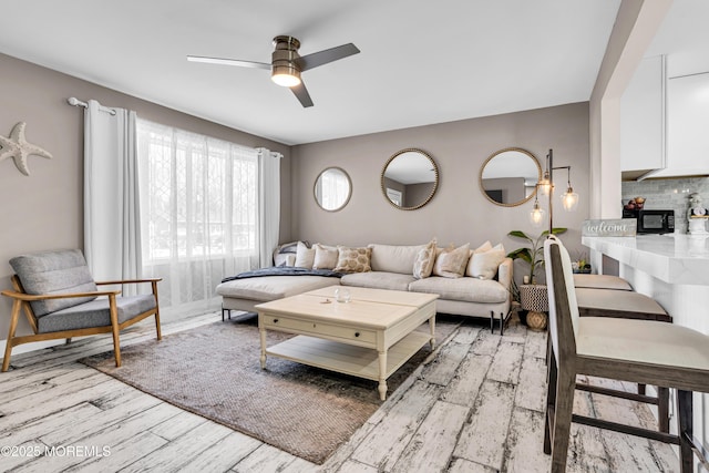 living room with ceiling fan and light wood-type flooring