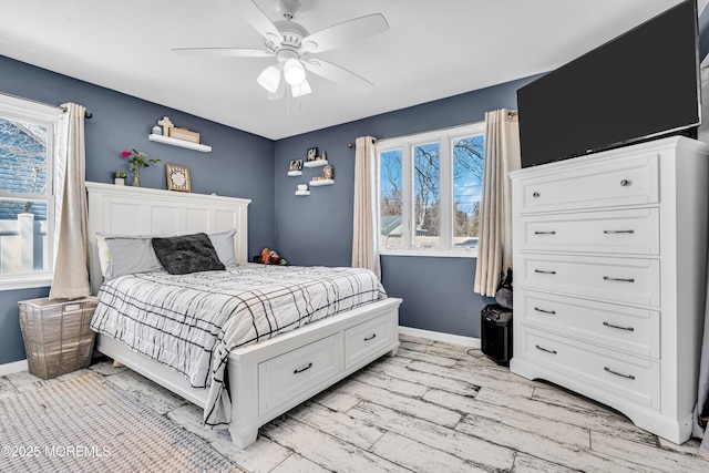 bedroom featuring light wood finished floors, multiple windows, and baseboards