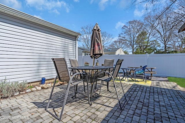 view of patio featuring outdoor dining space and fence