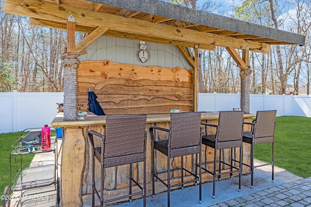 view of patio with outdoor dry bar and a fenced backyard
