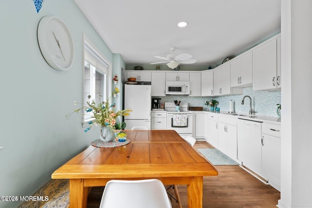 kitchen with decorative backsplash, a sink, a ceiling fan, and white appliances