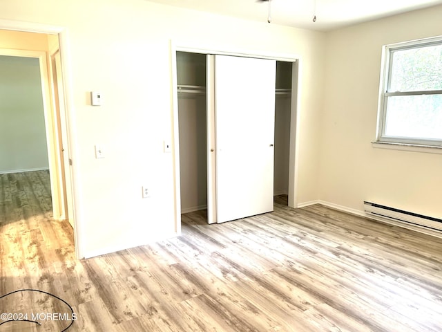 20 Lexington Dr Unit B, Whiting, NJ 08759 - unfurnished bedroom featuring light wood-style floors, a closet, baseboards, and baseboard heating