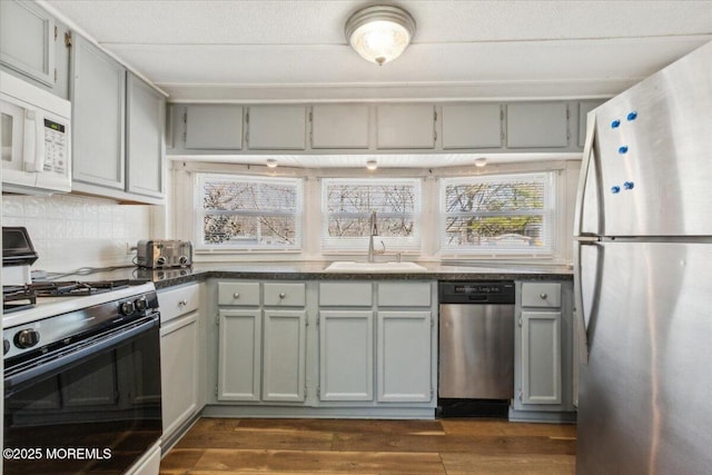 212 Roberts Rd, Toms River, NJ 08755 - kitchen with gray cabinetry, dark countertops, a sink, and appliances with stainless steel finishes
