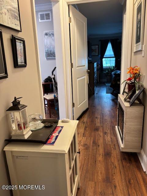 hall featuring visible vents and dark wood-type flooring