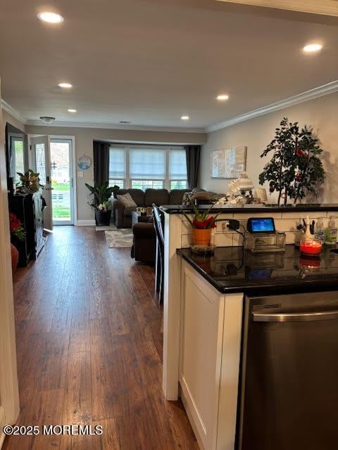 kitchen featuring crown molding, dark countertops, dark wood-style floors, open floor plan, and dishwasher
