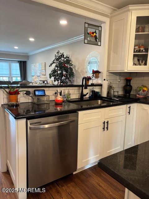 kitchen featuring dark wood-type flooring, stainless steel dishwasher, crown molding, and a sink