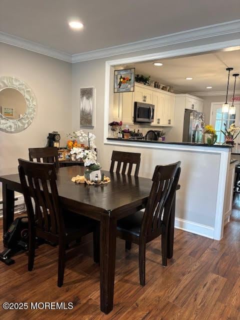 dining space with recessed lighting, ornamental molding, and dark wood finished floors